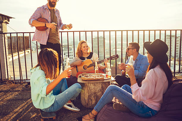 friends making their own party on the rooftop and having fun on a nice sunny afternoon